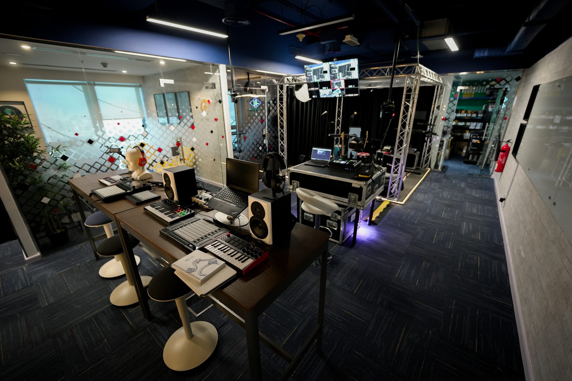 A working room at MCX: benches and monitoring in the foreground, truss, flight case and power runs behind them